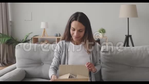 惊讶的年轻女子打开纸板箱与互联网商店的订单视频的预览图
