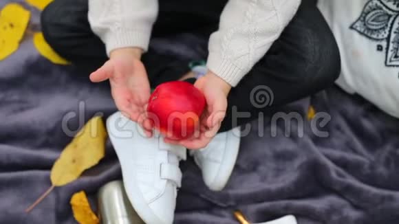 一个男孩手中的红苹果特写视频的预览图