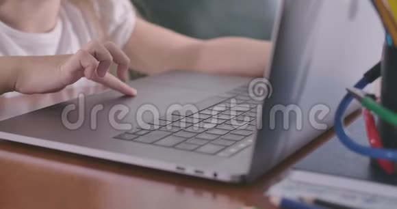 用笔记本电脑特写儿童的手使用触摸板的女学生教育电子学习在线信息社会媒体视频的预览图