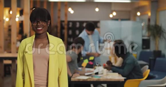 非洲裔美国女商人站在现代办公室里微笑着看着镜头工作人员视频的预览图