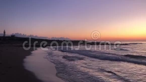 灯塔和日落时的波浪塞浦路斯帕福斯视频的预览图