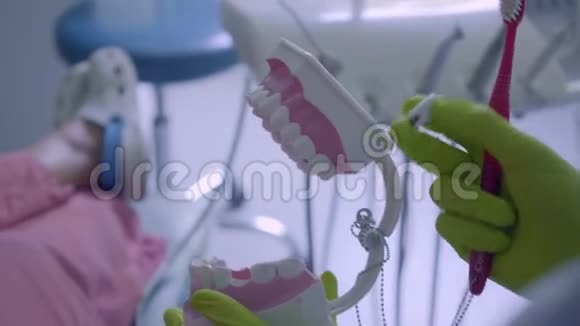 特写女性双手戴手套刷牙下巴模拟牙科治疗医学理念牙科护理视频的预览图