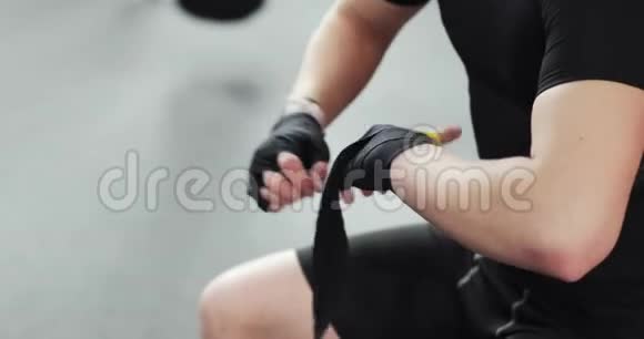 拳击手在拳击或健身房训练前用手胶带包扎特写双手视频的预览图