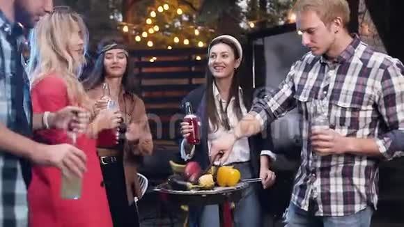 快乐可爱的年轻伴侣在烤架上用不含酒精的饮料和煮熟的蔬菜跳舞视频的预览图