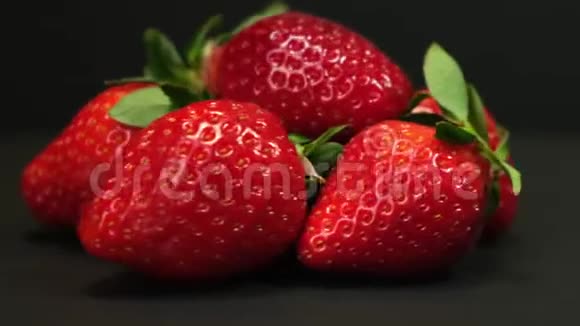 新鲜草莓在黑色背景上旋转快关门视频的预览图