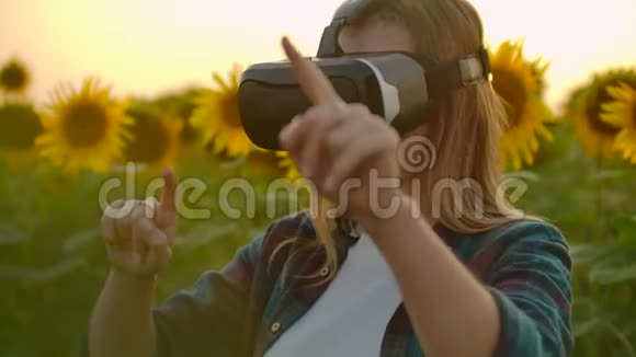 这名女学生正在日落时戴着VR眼镜工作视频的预览图