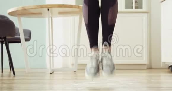 运动型女人的腿在厨房的家里跳绳做有氧运动训练视频的预览图