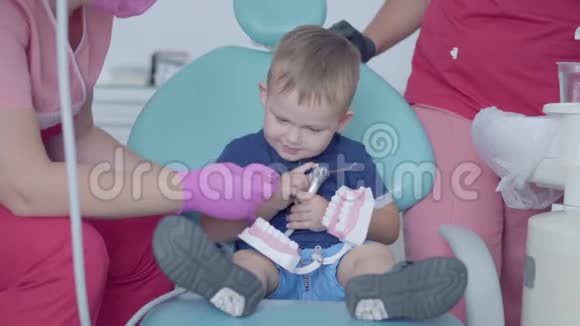 可爱的小男孩在牙医办公室玩着假牙无忧无虑的儿童看病牙科治疗视频的预览图