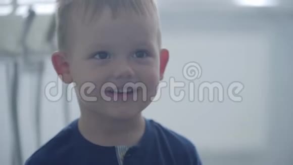 一个可爱有趣的微笑男孩的肖像拇指向上看着相机托管儿童出诊医生视频的预览图