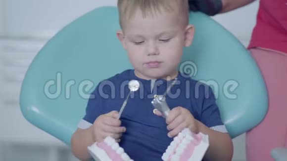 牙医办公室里可爱的小男孩在女医生和护士的帮助下玩下巴模拟免费儿童视频的预览图