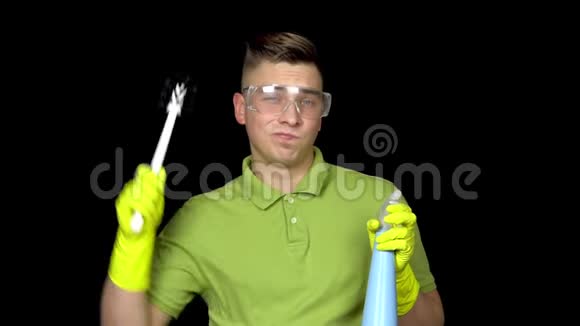 一个年轻人用马桶刷刮他的头人戴安全眼镜和手套清洁厕所那个家伙视频的预览图