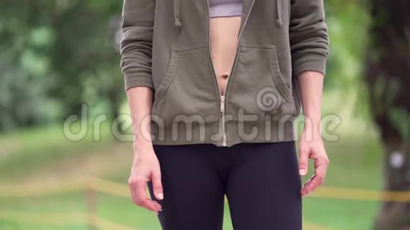早上在绿色城市公园慢跑时穿着紧身连帽衫的年轻有魅力的女士就会在户外活动视频的预览图