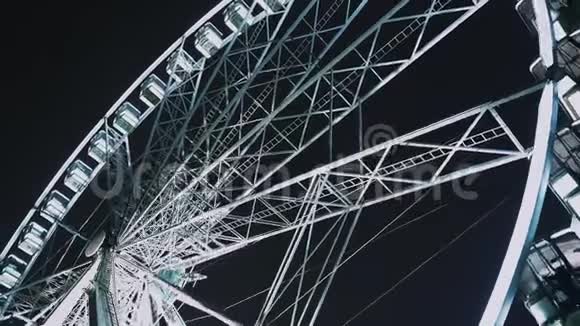 明亮的摩天轮乘坐在晚上或晚上的狂欢节旋转视频的预览图