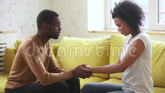 爱非裔美国丈夫牵着悲伤的妻子的手安慰视频的预览图