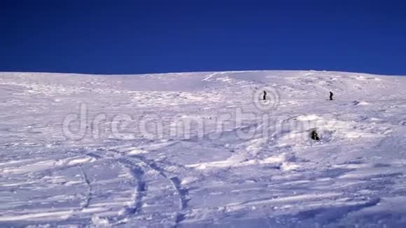 两个滑雪者在一个山脉的背景下降落在一个雪坡上在大雪纷飞的冬天危险的自由视频的预览图