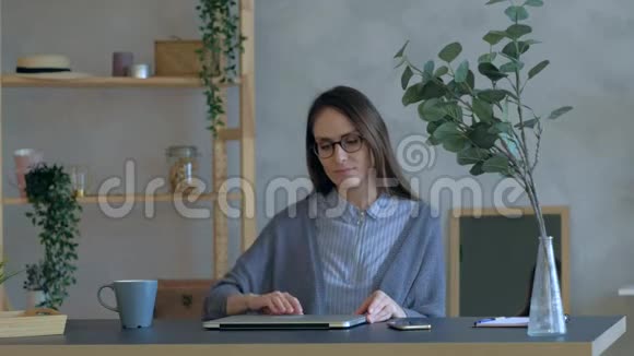 办公室里的女人打开笔记本电脑对网上的好消息感到惊讶视频的预览图