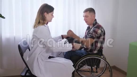 医疗保健坐轮椅的病人检查医生用医疗器械测量给他的压力视频的预览图