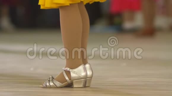 特写镜头穿着舞厅舞鞋的儿童的腿在地板上跳舞视频的预览图