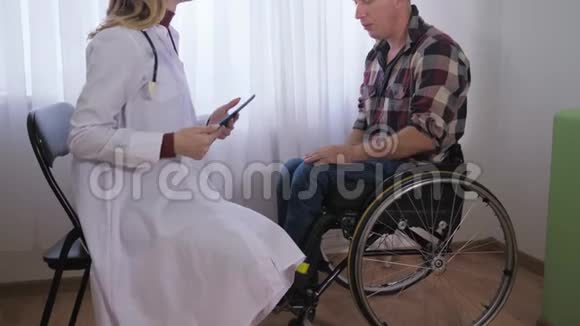 在医疗检查过程中轮椅上的男性患者向女医生讲述自己的健康问题视频的预览图