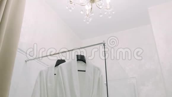 男女白袍挂在衣架上视频的预览图