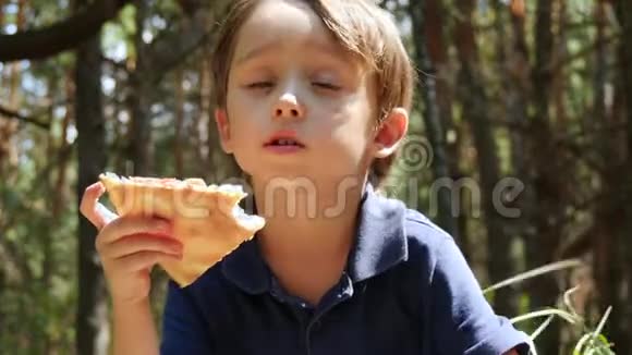一个小男孩的肖像孩子咬掉一片比萨饼吃了它户外娱乐小吃视频的预览图