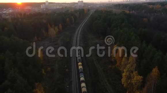 鸟瞰秋季在乡村场景下火车火车在日出时穿过农村火车视频的预览图