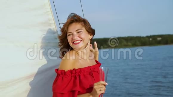 美丽的女人微笑着看着相机在帆船上放松视频的预览图