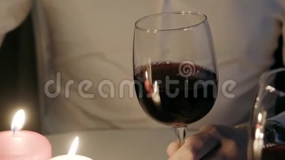 一个人把红酒从瓶子里倒进玻璃杯蜡烛在燃烧视频的预览图