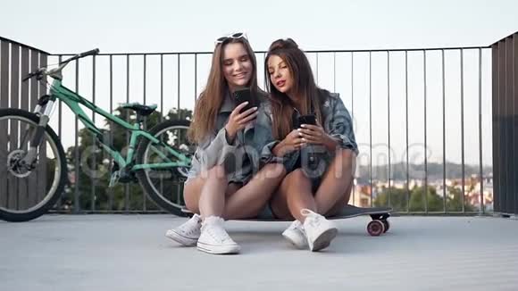 30岁的女朋友坐在滑板上在看手机照片时玩得很开心视频的预览图