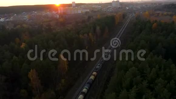 鸟瞰秋季在乡村场景下火车火车在日出时穿过农村火车视频的预览图