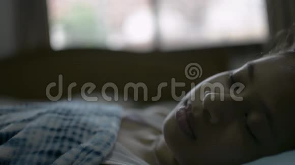 闭上可爱的亚洲女孩睡在她即将醒来的床上视频的预览图