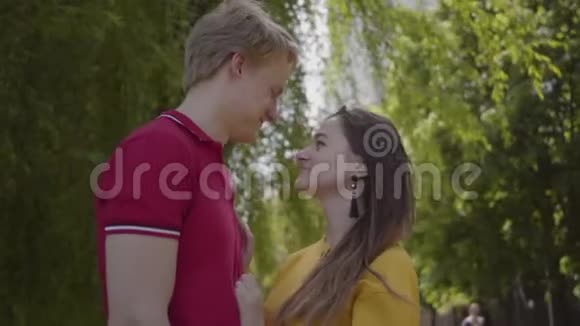 可爱的白种人夫妇在绿泉公园的背景下温柔地拥抱和微笑年轻日期视频的预览图