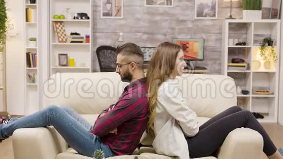 两人背靠背坐在沙发上交叉双臂视频的预览图