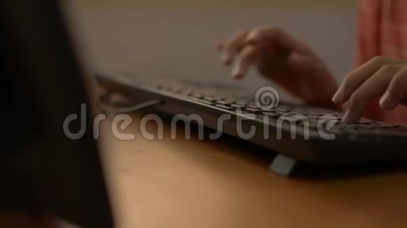 在COVID19疫情爆发期间一名女孩在家里的桌子上用电脑键盘打字视频的预览图