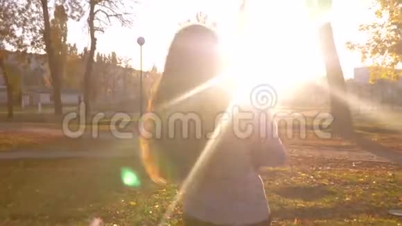 快乐的妈妈带着一个小孩在阳光下的城市公园里散步妈妈和女儿在公园里玩视频的预览图
