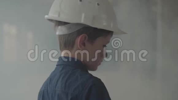 可爱的男孩戴着防护头盔肮脏的脸看着相机走在烟雾中儿童视频的预览图