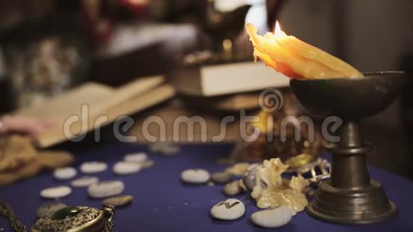 占星术和神秘主义一支歪歪扭扭的蜡烛燃烧把蜡滴在桌子上在这种背景下一位女算命先生视频的预览图