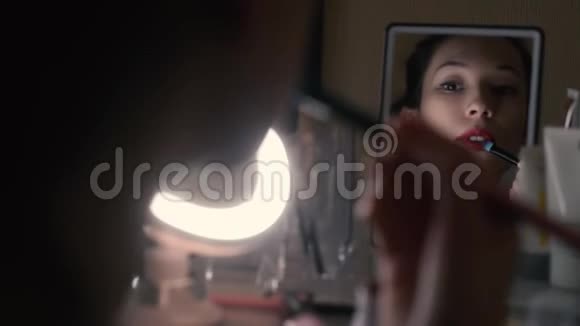 女人在镜子里放红唇膏晚上化妆准备去参加聚会视频的预览图