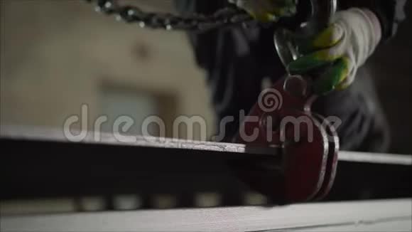 一个工人把金属片钩到起重机上起重机链条和钩子在一个工业工厂钢吊钩视频的预览图