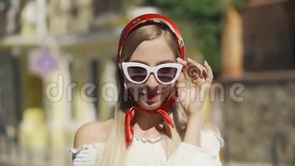 一幅美丽的年轻女子戴着墨镜看着镜头的肖像头上披着红色披肩视频的预览图