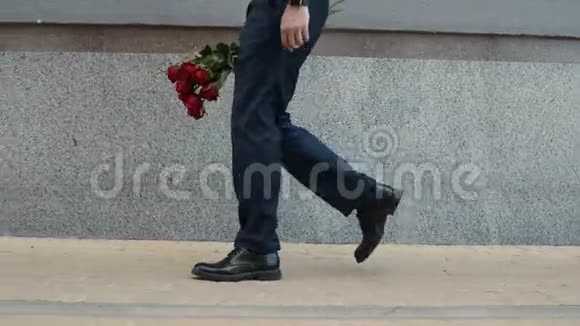 特写男在街上拿着玫瑰手捧红玫瑰的男人在街上视频的预览图
