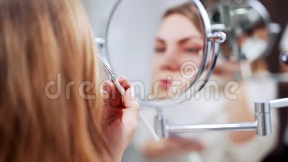 在家镜子前用阴影板化妆的美女美化妆品艺术家概念视频的预览图