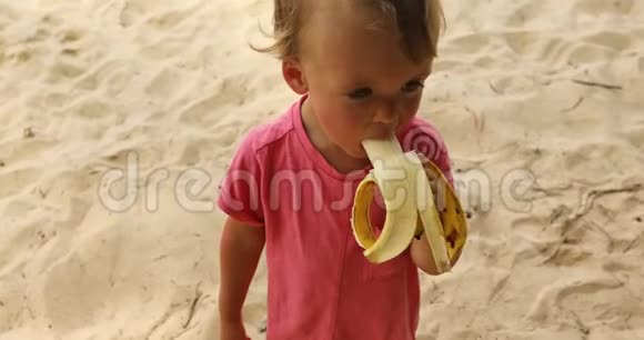 孩子在海滩上吃香蕉视频的预览图