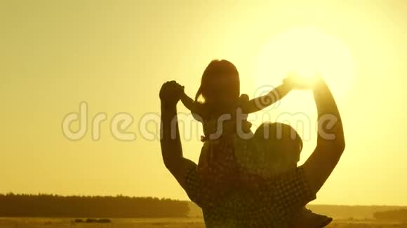 父亲在阳光下和孩子玩快乐的童年概念小女儿和爸爸一起骑在肩膀上视频的预览图