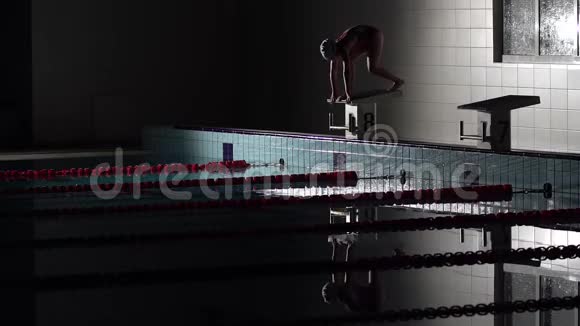 少女游泳者在游泳池里潜水女游泳运动员潜入游泳池游泳夜间射击视频的预览图