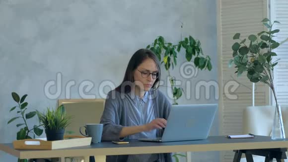 在办公室里穿着紧身衣的年轻女人用坏掉的笔记本电脑感到恼火视频的预览图