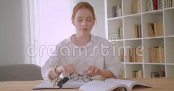 年轻可爱的红头发女学生戴着带马尾辫的眼镜用平板电脑写着特写肖像视频的预览图
