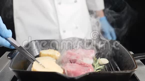 厨师在烤架上用肉煮土豆用汤匙在烧烤上烤土豆慢动作冒烟高清高清视频的预览图