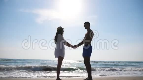海景背景下的新婚夫妇年轻人站在膝盖上向女友求婚视频的预览图