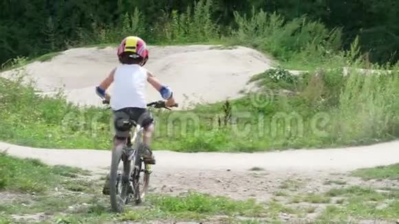 男孩小学生骑自行车在公路上摔倒在地视频的预览图